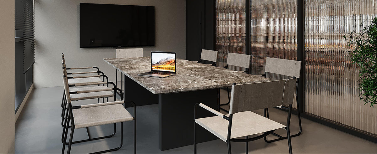Modern office meeting room with a large desk, chairs, and a TV.